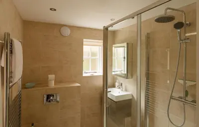 a bathroom with a glass shower and a sink at Honeysuckle Cottage in Thornham Magna