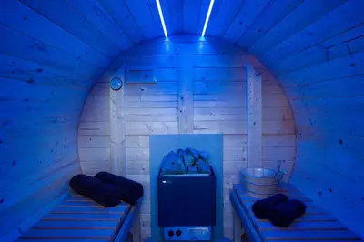 a blue room with two beds and a refrigerator at Honeysuckle Cottage in Thornham Magna