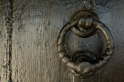 an old wooden door with a metal knocker on it at Honeysuckle Cottage in Thornham Magna
