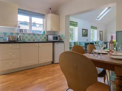 a kitchen and dining room with a table and chairs at Bluebell Studio in Saxmundham