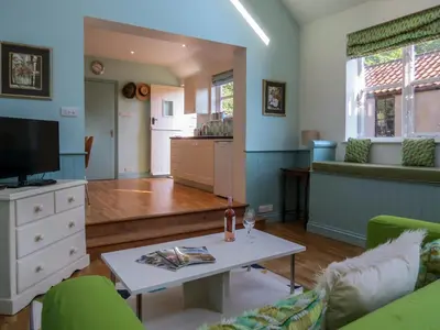 a living room with a couch and a table at Bluebell Studio in Saxmundham