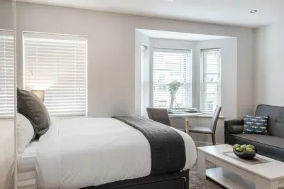 a bedroom with a bed and a table and chairs at Tailored Stays - Central Cambridge Studios, Free Parking in Cambridge