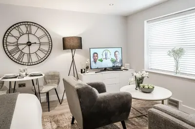 a living room with a large clock on the wall at Tailored Stays - Central Cambridge Studios, Free Parking in Cambridge