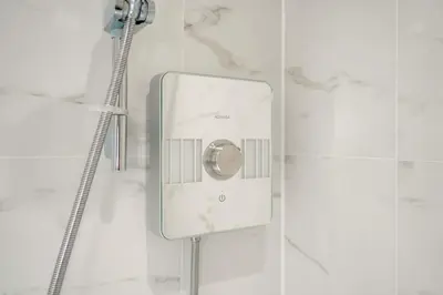 a shower in a white tiled bathroom with at Tailored Stays - Central Cambridge Studios, Free Parking in Cambridge