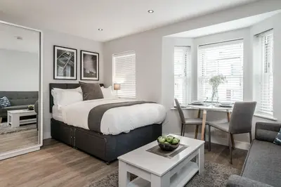 a bedroom with a bed and a living room at Tailored Stays - Central Cambridge Studios, Free Parking in Cambridge