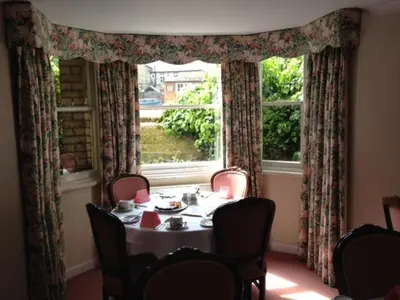 a dining room with a table and a window at Ashley Hotel in Cambridge