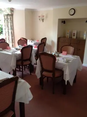 a dining room with tables and chairs with white table cloth at Ashley Hotel in Cambridge