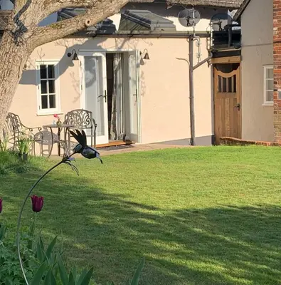 a bird sitting on a flower in a yard at Corner House Luxury BnB in Little Dunmow