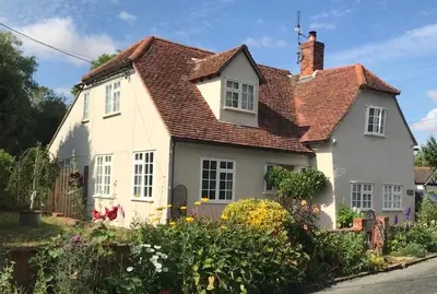 a white house with a red roof at Corner House Luxury BnB in Little Dunmow