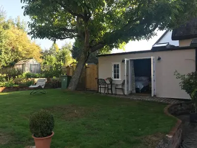 a backyard with a bedroom and a tree at Corner House Luxury BnB in Little Dunmow