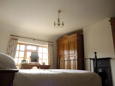 a bedroom with a bed and a window and a chandelier at One Pelham Grove Bed & Breakfast in Stocking Pelham