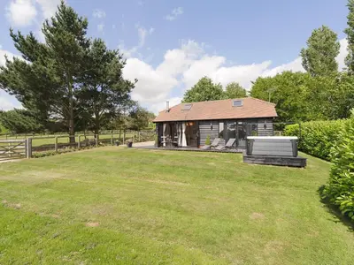 a house with a large yard in front of it at Toad Hall Cottage in Earls Colne