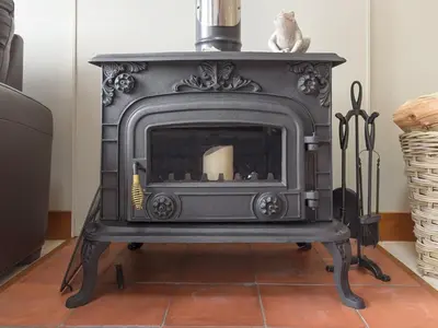 a black stove sitting on top of a floor at Toad Hall Cottage in Earls Colne