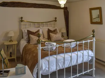 a bedroom with a bed with a metal frame at Lavenham Red Brick Cottage in Lavenham