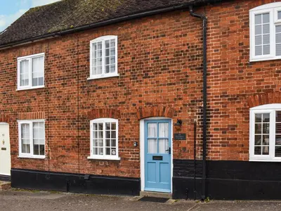 a red brick building with a blue door at Lavenham Red Brick Cottage in Lavenham