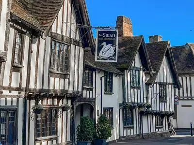 an old building with a sign on the side of it at Lavenham Red Brick Cottage in Lavenham