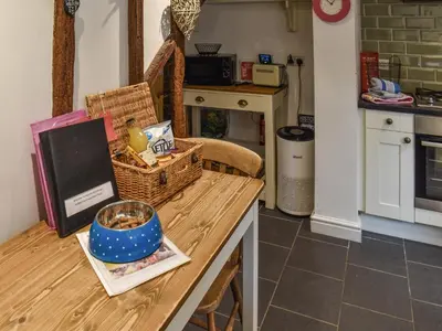 a kitchen with a table with baskets on it at Lavenham Red Brick Cottage in Lavenham