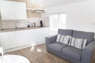 a living room with a couch and a kitchen at Citystay Living - Devonshire Road in Cambridge