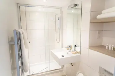 a white bathroom with a shower and a sink at Citystay Living - Devonshire Road in Cambridge