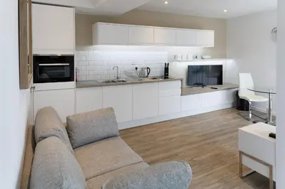 a living room with a couch and a kitchen at Citystay Living - Devonshire Road in Cambridge