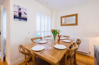 a dining room with a wooden table and chairs at Maisie's in Aldeburgh