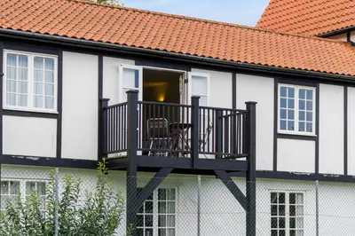 a black and white house with a balcony at 4 Bell Lodge, Thorpeness in Thorpeness