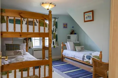 a bedroom with two bunk beds and a staircase at 4 Bell Lodge, Thorpeness in Thorpeness