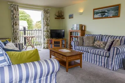 a living room with two couches and a television at 4 Bell Lodge, Thorpeness in Thorpeness