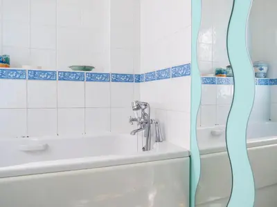 a bathroom with a bath tub and a sink at 4 Bell Lodge, Thorpeness in Thorpeness