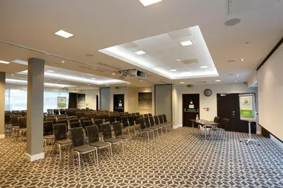 a conference room with chairs and a podium in the middle at Holiday Inn Southend by IHG in Southend-on-Sea