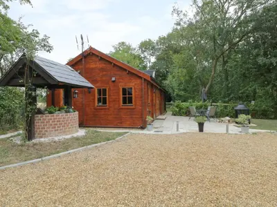 a wooden cabin with a pavilion in a garden at Acorn Lodge in Saxmundham
