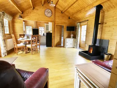 a living room with a fireplace and a dining room at Acorn Lodge in Saxmundham