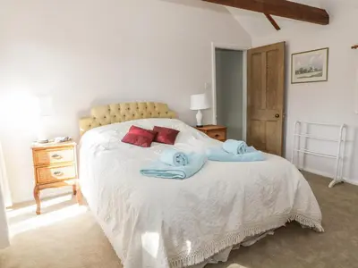 a bedroom with a bed with two towels on it at Stable Cottage in Sudbury