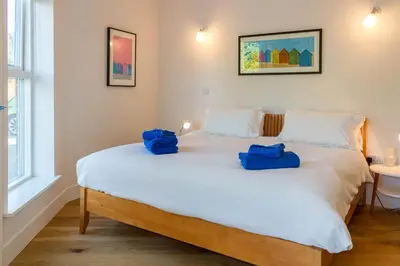 a bedroom with a large bed with blue bags on it at Robin's Egg in Aldeburgh