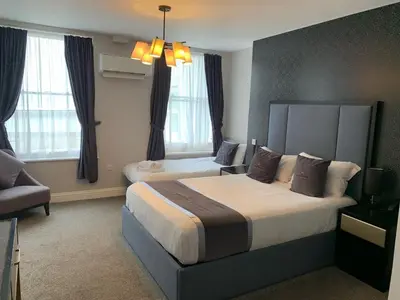 a hotel room with a large bed and a couch at The Royal Hotel - Clacton On Sea in Clacton-on-Sea
