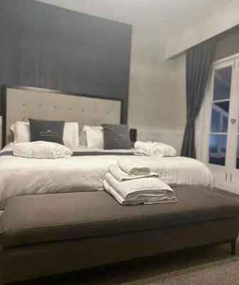 a bedroom with two beds with towels on a bench at The Royal Hotel - Clacton On Sea in Clacton-on-Sea