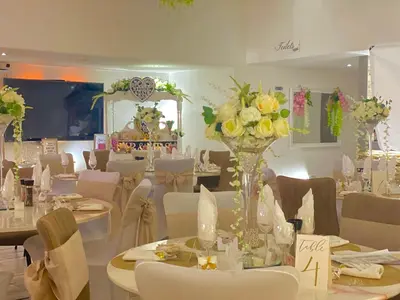 a room with tables and chairs with flowers on them at The Royal Hotel - Clacton On Sea in Clacton-on-Sea