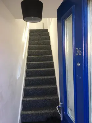 a stairway with a blue door and a blue door at Detached Coach House in Colchester