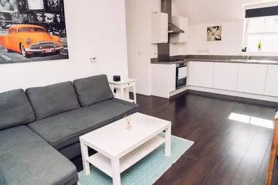 a living room with a couch and a table at Detached Coach House in Colchester