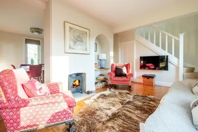 a living room with two chairs and a fireplace at Briar Hill in Aldringham