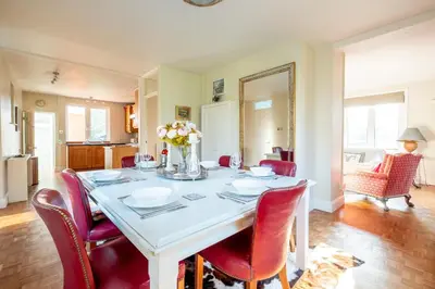 a dining room with a white table and red chairs at Briar Hill in Aldringham
