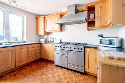 a kitchen with wooden cabinets and a stainless steel stove at Briar Hill in Aldringham