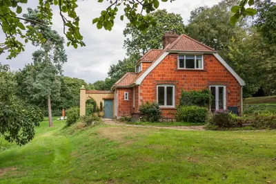 a red brick house on a grassy field at Briar Hill in Aldringham