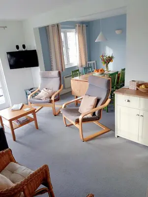 a living room with two chairs and a table at 1 Bell Lodge, Thorpeness in Thorpeness