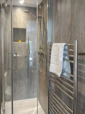 a shower with a glass door in a bathroom at Meadow View, Near Aldeburgh in Aldringham