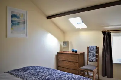 a bedroom with a bed and a chair and a dresser at The Old Bottle Store - 2 Double Bedrooms, 2 Bathrooms, St Ives, Cambridgeshire in St Ives