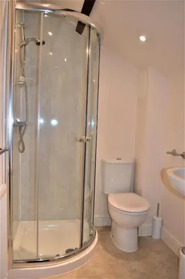 a bathroom with a shower with a toilet and a sink at The Old Bottle Store - 2 Double Bedrooms, 2 Bathrooms, St Ives, Cambridgeshire in St Ives