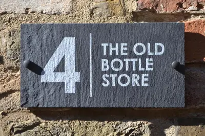 a sign on a brick wall with the bottle store at The Old Bottle Store - 2 Double Bedrooms, 2 Bathrooms, St Ives, Cambridgeshire in St Ives
