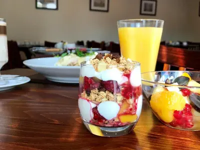 a wooden table with two glasses filled with fruit and nuts at The Bird in Hand in Ashwellthorpe