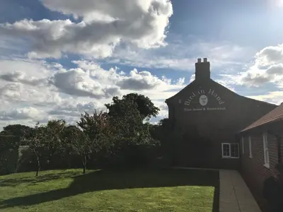 a building with a sign on the side of it at The Bird in Hand in Ashwellthorpe